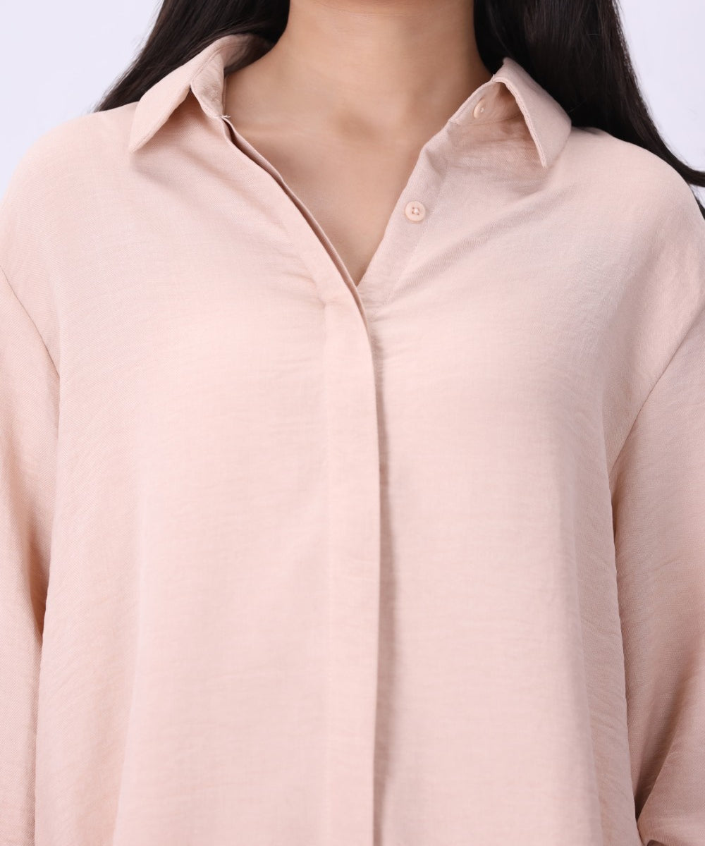 Blush shirt worn open over a tank top
