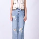 Close-up of geometric embroidery detail on ivory vest