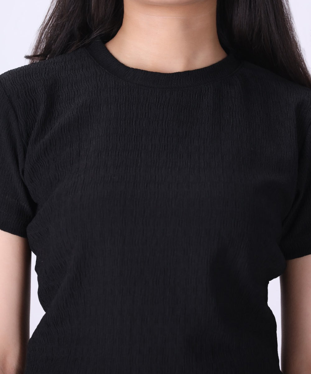 Close-up of ribbed knit texture on black t-shirt
