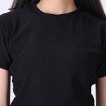 Close-up of ribbed knit texture on black t-shirt
