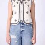 Embroidered vest layered over a plain tee and denim
