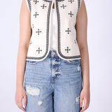 Embroidered vest layered over a plain tee and denim

