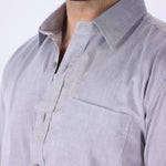 Grey shirt tucked into tailored trousers