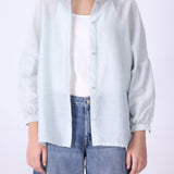 Light blue button-down shirt worn open over a tank
